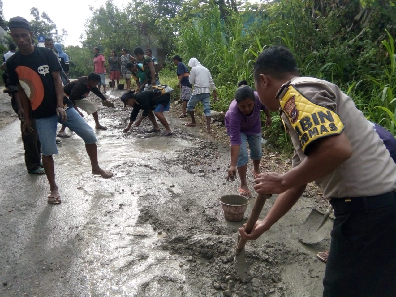 Bhabinkamtibmas Polsek Lamaknen Bantu Warga Perbaiki Jalan Yang Rusak dan Berlubang